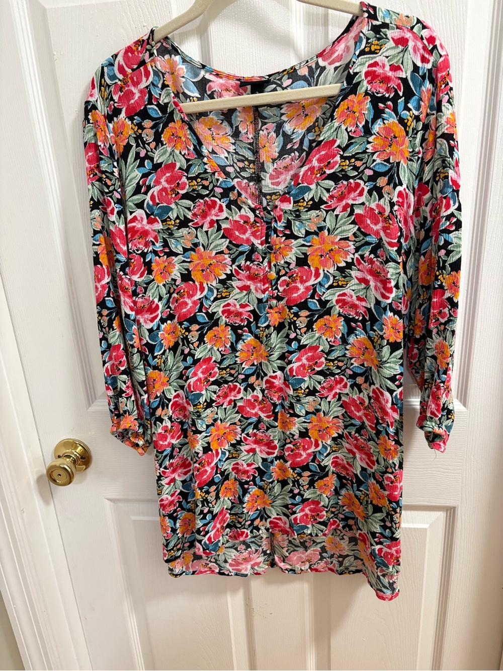 Torrid floral tunic features a colorful V-neck design with 3/4 sleeves.